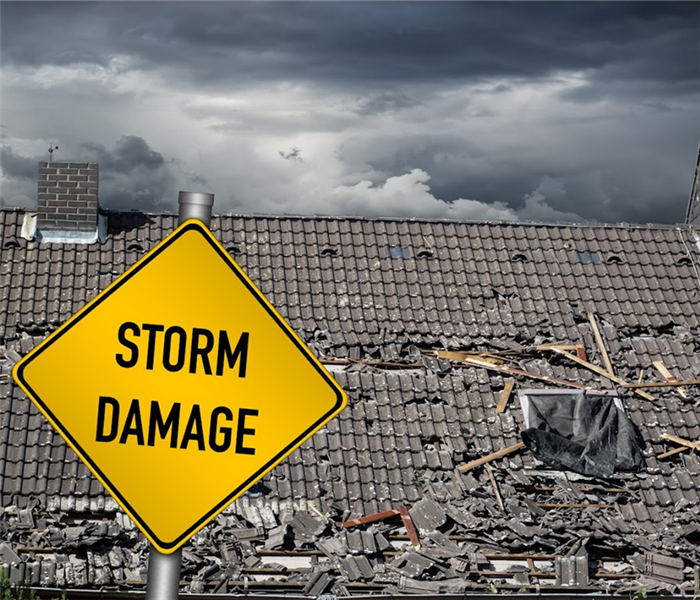 a storm damaged house with a storm damage sign in front of it