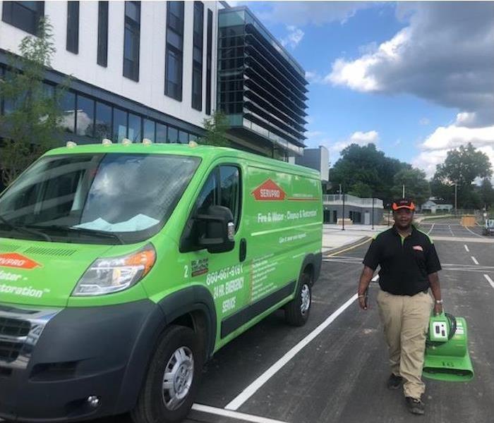 Employee carrying equipment by a SERVPRO van